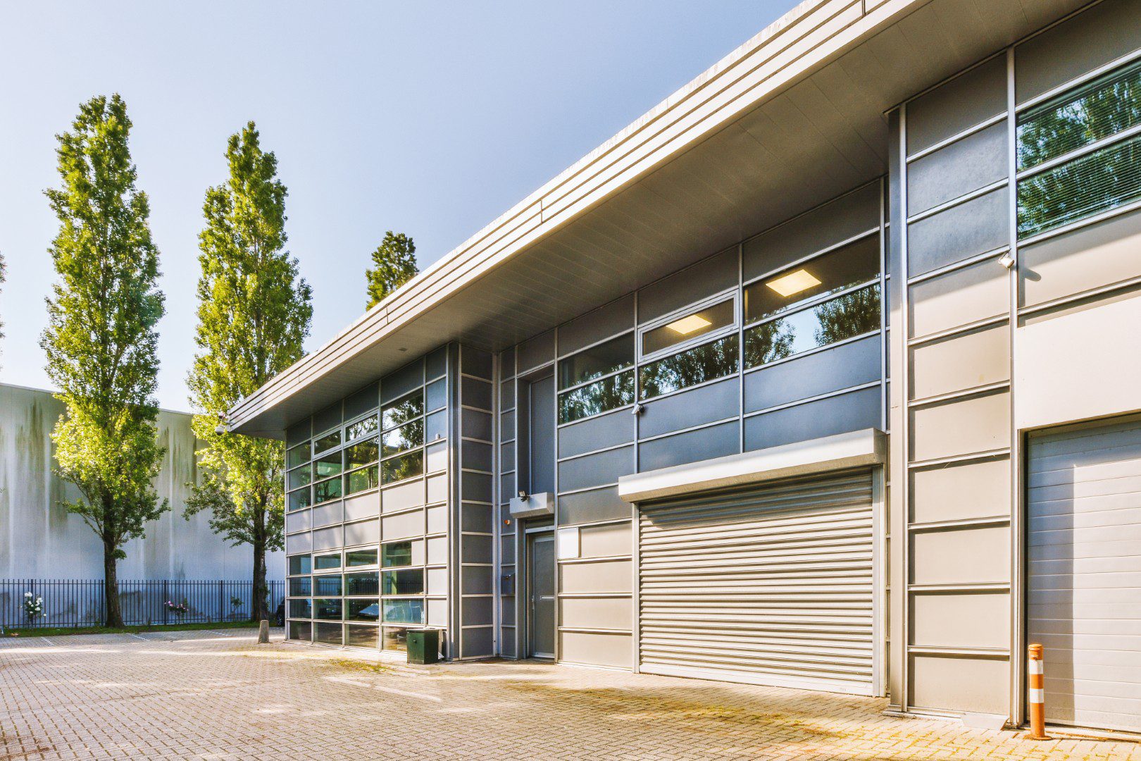 The facade of a brick building with wooden door A modern strata warehouse unit with a roller door and a glazed office frontage