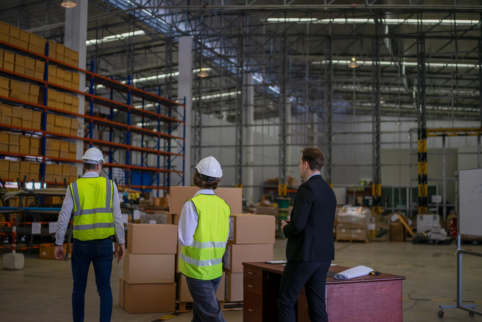 Blue collar workers are working and meeting at warehouse.